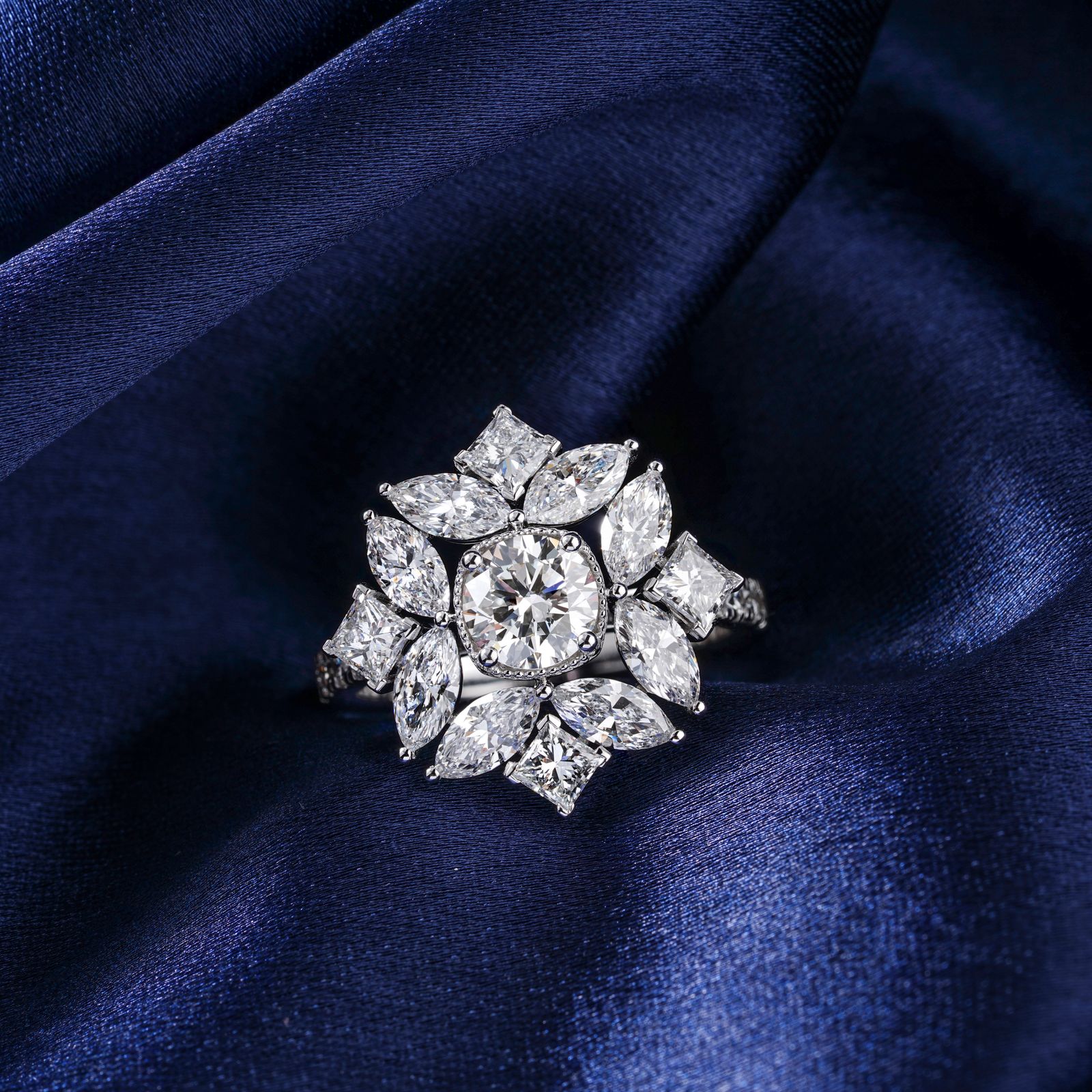 Cushion-cut diamond statement ring framed by marquise and princess-cut stones on midnight-blue satin